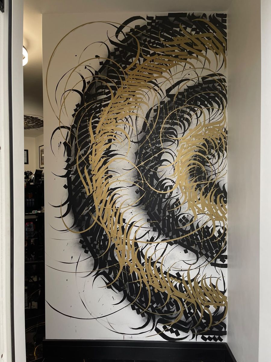 Hand-painted gold calligraphy artwork in the studio